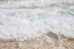海洋波崩溃成的海滩在的一天夏天