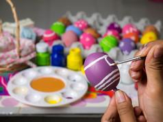着色鸡蛋与各种各样的颜色漂亮的与的刷在的复活节女人油漆复活节鸡蛋美丽的艺术鸡蛋复活节节日
