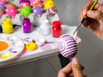 着色鸡蛋与各种各样的颜色漂亮的与的刷在的复活节女人油漆复活节鸡蛋美丽的艺术鸡蛋复活节节日