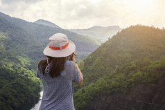 快乐旅行者女人放松与背包和看令人惊异的山和森林夏天一天夏天假期户外假期旅行