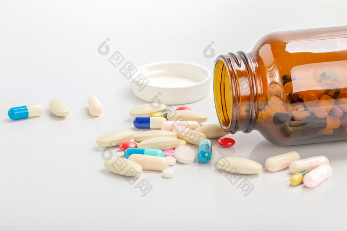 特写镜头药片胶囊溢出出药丸瓶孤立的背景医疗保健和医疗药物概念