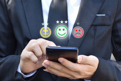 商人紧迫的脸表情符号智能手机显示虚拟屏幕概念客户服务满意度评价和反馈