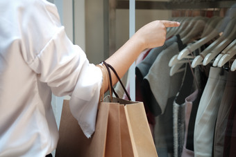 年轻的女人持有出售购物袋消费主义生活方式概念的购物购物中心