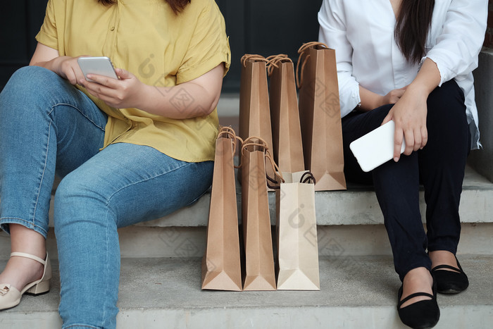 年轻的女人持有出售购物袋消费主义生活方式概念的购物购物中心
