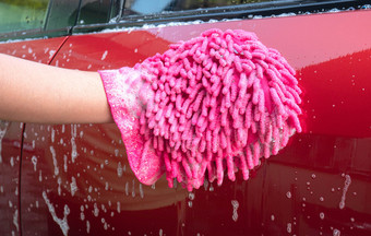 女手持有粉红色的我与泡沫为洗车
