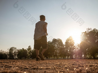 亚洲高级男人。慢跑的公园在日落天空背景健康的生活方式和医疗保健概念