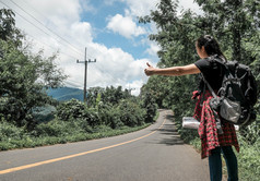 旅行女人徒步旅行搭便车的路在夏天假期旅行令人惊异的景观自然泰国旅行和搭便车概念