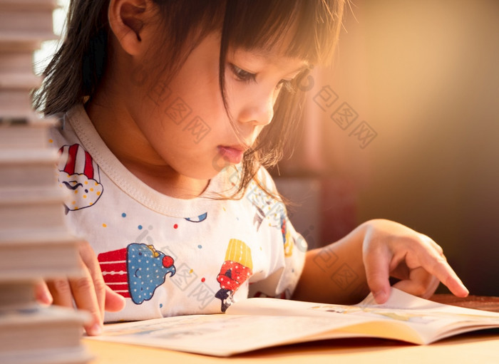 小可爱的女孩阅读书坐在表格首页保持首页检疫从冠状病毒流感大流行自主学习概念