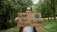 女志愿者持有自然保护标志站在的自然的森林的概念世界环境一天