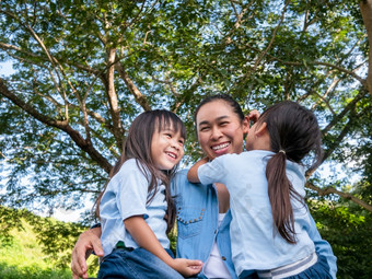 两个兄弟姐妹小女孩与<strong>妈妈</strong>笑和拥<strong>抱</strong>每一个其他温暖的和阳光明媚的夏天一天的花园年轻的女孩与她的<strong>妈妈</strong>。支出一天公园