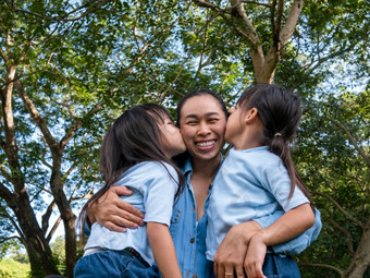 两个兄弟姐妹小女孩与<strong>妈妈</strong>笑和拥<strong>抱</strong>每一个其他温暖的和阳光明媚的夏天一天的花园年轻的女孩与她的<strong>妈妈</strong>。支出一天公园