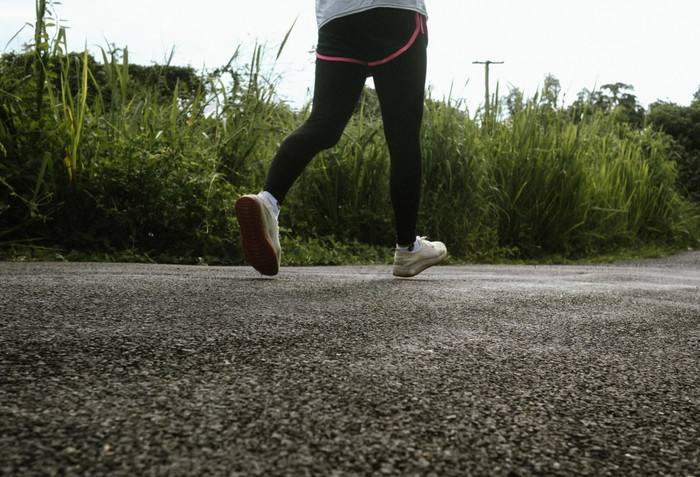 女跑步者运行的路小道早....培训为马拉松和健身健康的生活方式概念运动员运行锻炼在户外特写镜头腿