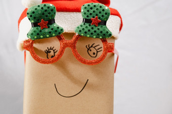 礼物盒子穿圣诞节眼镜和圣诞老人他与微笑脸的表格附近的圣诞节树首页快乐新一年和快乐圣诞节
