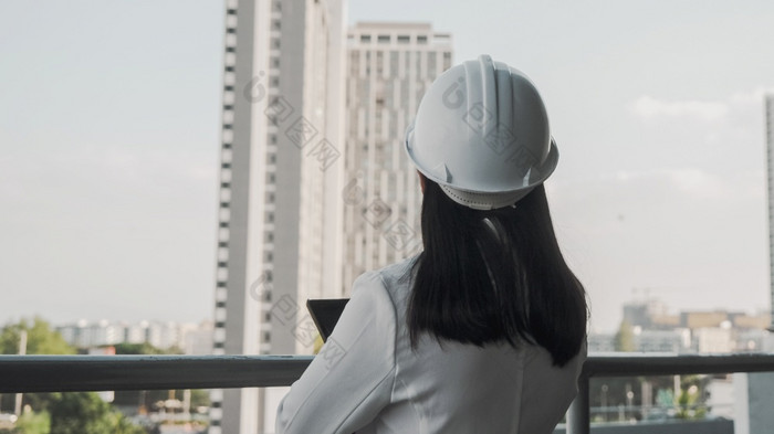 女建设工程师与平板电脑电脑建设网站自信女人架构师白色头盔看建设网站建设和体系结构概念