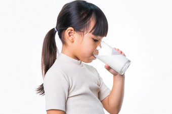 亚洲小可爱的女孩喝牛奶从玻璃白色背景工作室健康的营养为小孩子们