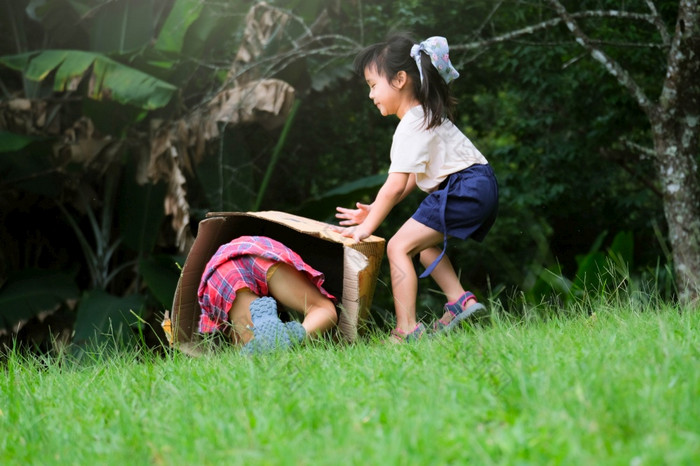 微笑小女孩坐在纸板盒子滑动下来山植物花园的著名的户外学习中心美卫生部我的公园lampang泰国快乐童年概念
