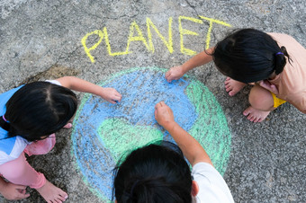 志愿者家庭<strong>油漆</strong>美丽的世界与的消息<strong>地球</strong>沥青小孩子们和年轻的女人画与色彩斑斓的粉笔院子里概念世界环境一天