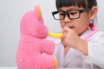 可爱的亚洲小女孩玩医生角色游戏给注射她的生病的泰迪熊朋友自主学习孩子们rsquo玩和学习