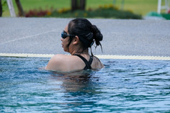 美丽的年轻的亚洲女人快乐和微笑游泳池亚洲女人泳衣游泳的蓝色的清洁水的游泳池为锻炼旅行和夏天假期概念