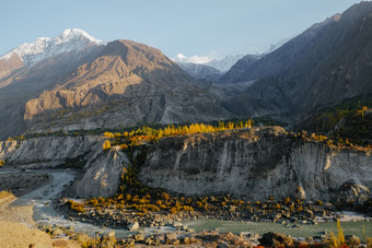 自然阳光闪亮的色彩斑斓的树和河对雪封顶山山峰喀拉昆仑山脉范围hunza纳加尔谷秋天季节吉尔吉特巴尔蒂斯坦<strong>巴基斯坦</strong>