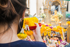 女人使仪式产品从花花环的erawan神社曼谷泰国