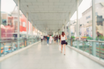 模糊背景图像人走人行天桥的城市包围购物购物中心和现代建筑曼谷泰国