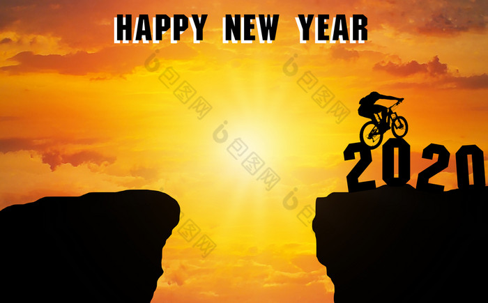 快乐新一年轮廓男人。红色山自行车和然后跳在的悬崖来日落时间