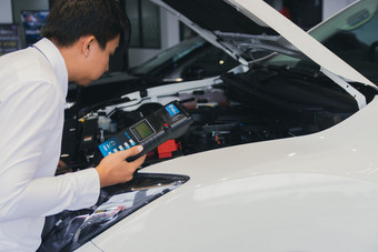 男人。检查持有电池能力测试人员电压表用于服务维护工业引擎repairin工厂运输<strong>汽车汽车图像</strong>