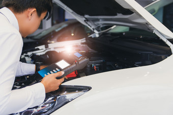 男人。检查持有电池能力测试人员电压表用于服务维护工业引擎repairin工厂运输汽车汽车图像