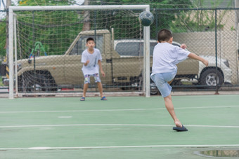 孩子们是<strong>穿拖鞋</strong>玩足球与模糊背景显示运动到锻炼后学校