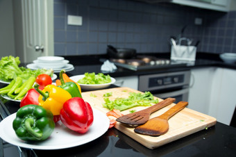 烹饪沙拉食物与蔬菜持有西红柿和<strong>胡萝卜</strong>贝尔辣椒板为快乐家庭烹饪食物享受生活方式厨房首页