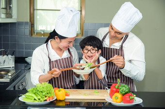 亚洲女人年轻的<strong>妈妈</strong>。与儿子男孩烹饪沙拉食物与蔬菜持有西红柿和胡萝卜贝尔<strong>辣</strong>椒板为快乐家庭烹饪食物享受生活方式厨房首页