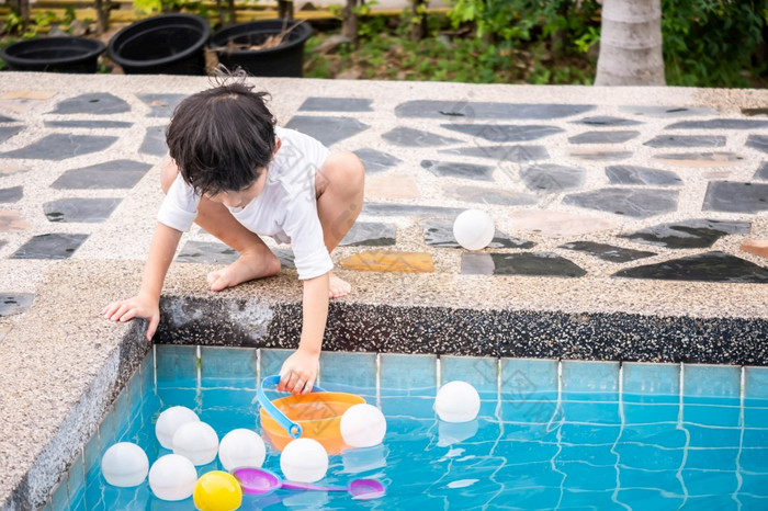 亚洲男孩儿子孩子们玩池玩具在游泳池边快乐学习生活与家庭有趣的学习和玩