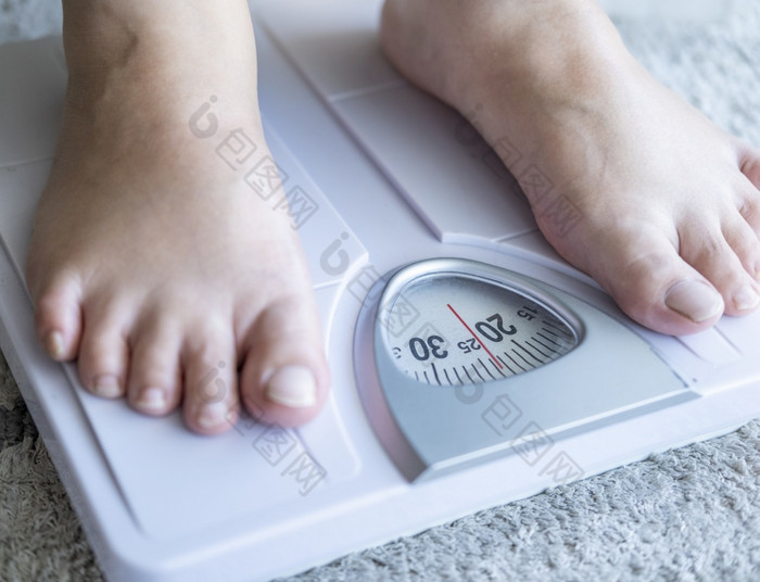 亚洲人脚男人。与身体重量尺度为测量重量损失重规模健康的减肥概念