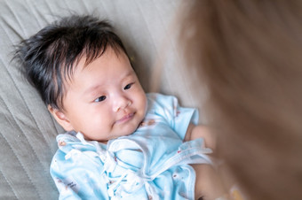 亚洲新生儿婴儿孩子眼睛联系与妈妈可爱孩子们与快乐家庭软床垫比喻生活生活健康的生活方式可爱的孩子婴儿产品健康产品为妈妈。和婴儿