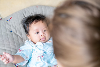 亚洲新生儿婴儿孩子眼睛联系与妈妈可爱孩子们与快乐家庭软床垫比喻生活生活健康的生活方式可爱的孩子婴儿产品健康产品为妈妈。和婴儿