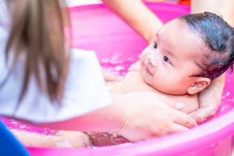 亚洲妈妈淋浴婴儿清洁污垢给孩子浴容器为清洁生活方式家庭之间的妈妈。和孩子使用为婴儿淋浴奶油产品洗发水乳液和婴儿哪产品