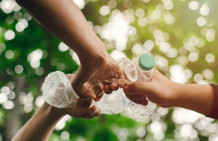 删除浪费节约更好的世界与好环境和自然大气手手团队团结持有塑料瓶在一起减少全球气候变暖保存的世界
