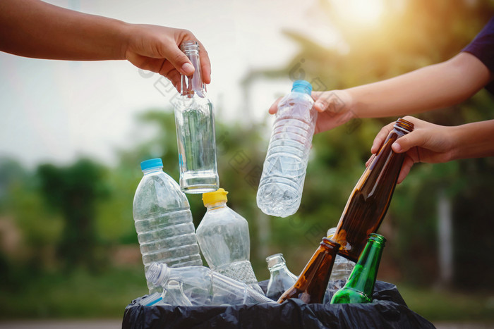人手持有垃圾瓶塑料和玻璃把成回收袋为清洁