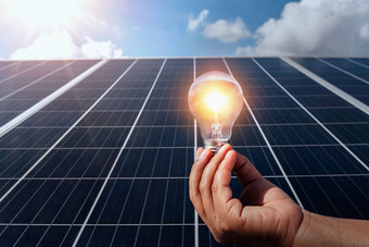手持有灯泡太阳能面板概念清洁能源自然