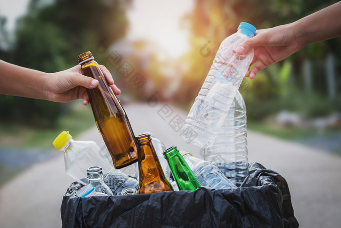 人手持有垃圾瓶塑料和玻璃把成回收袋为清洁