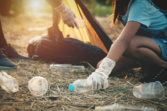 女人手挑选垃圾塑料瓶为清洁公园