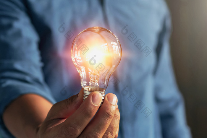 商人手持有灯泡的想法替代能源概念储蓄电