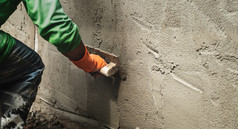 特写镜头手工人抹水泥墙为建筑房子