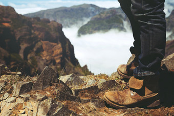 旅行者休息男人。赶时髦的人徒步旅行靴子站高山峰有享受美妙的惊人的的森林山岩石视图自由旅行概念徒步旅行鞋子和男人。腿