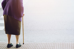 上了年纪的老女人与走坚持站等待小径人行道上穿越的街独自一人概念高级在的街斑马人行横道