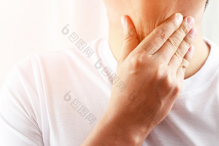 痛喉咙疼痛特写镜头年轻的男人。生病的持有她的发炎喉咙使用手触摸的生病了脖子蓝色的衬衫灰色的背景医疗和医疗保健概念焦点红色的显示疼痛
