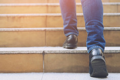 关闭腿鞋子年轻的业务男人。一个人走步进会的楼梯现代城市成功成长与过滤器音调复古的古董温暖的效果楼梯