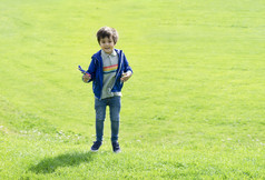 完整的长度肖像孩子跳的绿色草可爱的小男孩玩塑料飞机玩具孩子有有趣的玩户外春天夏天场阳光明媚的一天