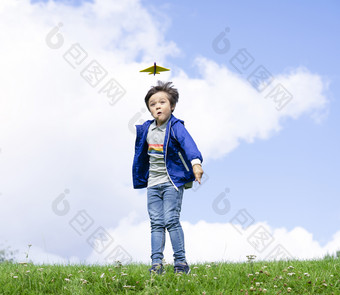 肖像活跃的小男孩玩与玩具飞机对绿色自然背景孩子扔泡沫飞机孩子玩的公园童年户外活动概念